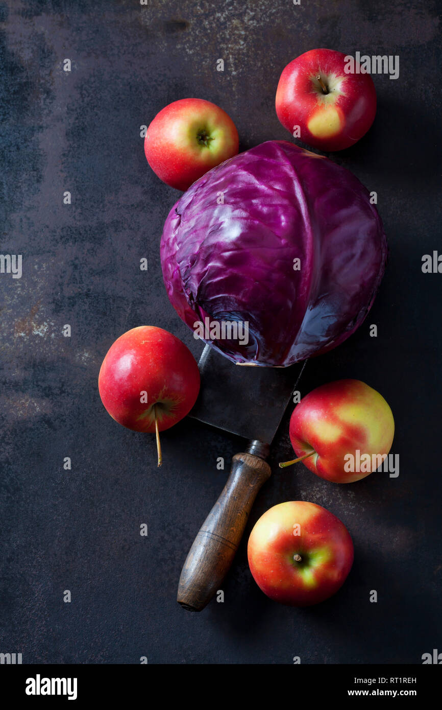 Red cabbage, apples and cleaver on rusty ground Stock Photo