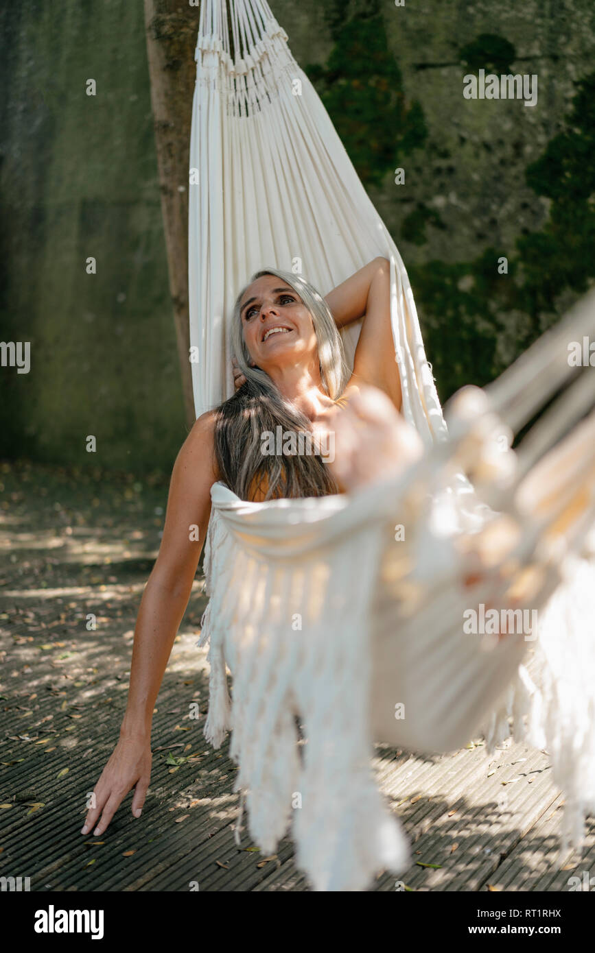 Happy woman relaxing in hammock in the garden Stock Photo - Alamy