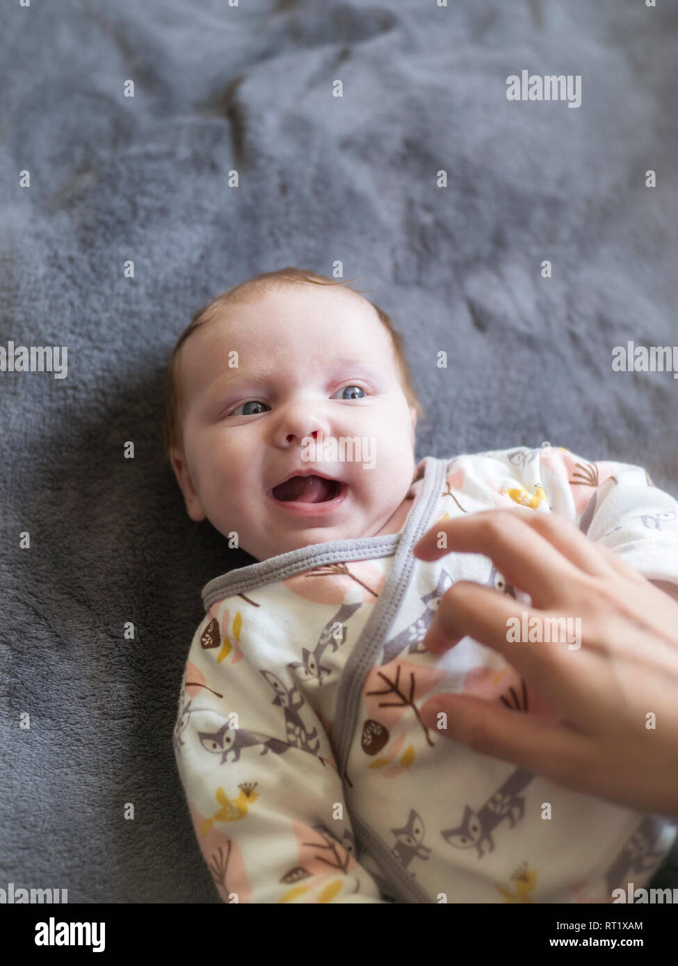 Mother tickling her laughing baby girl Stock Photo