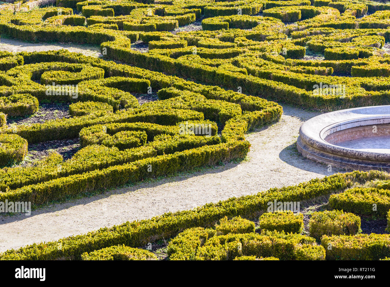 The parterre de broderie in the french formal garden of the castle of Auvers-sur-Oise with beds of boxwood pruned in geometrical shapes around a basin Stock Photo