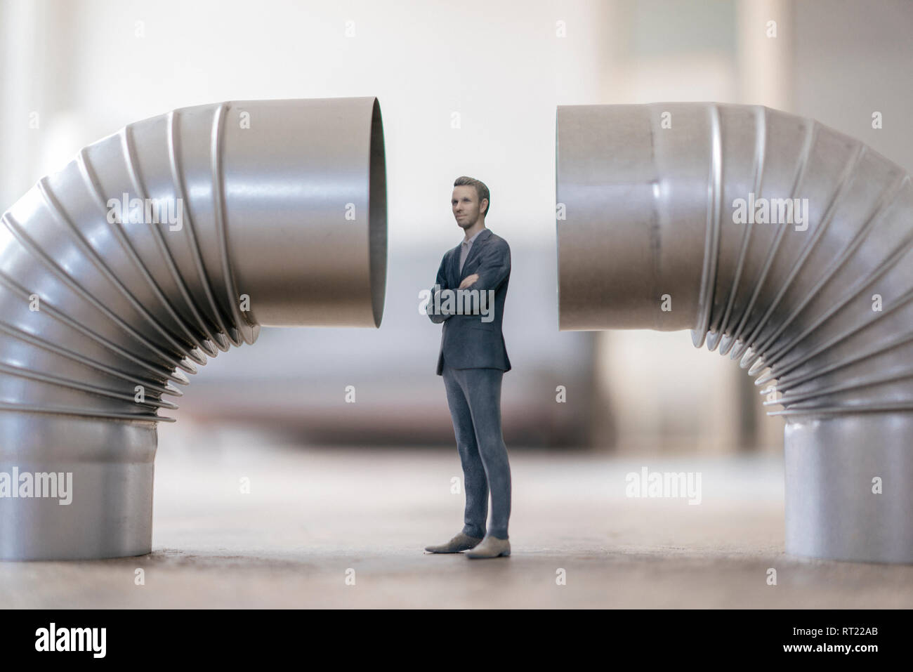 Businessman figurine standing between two stove pipes Stock Photo