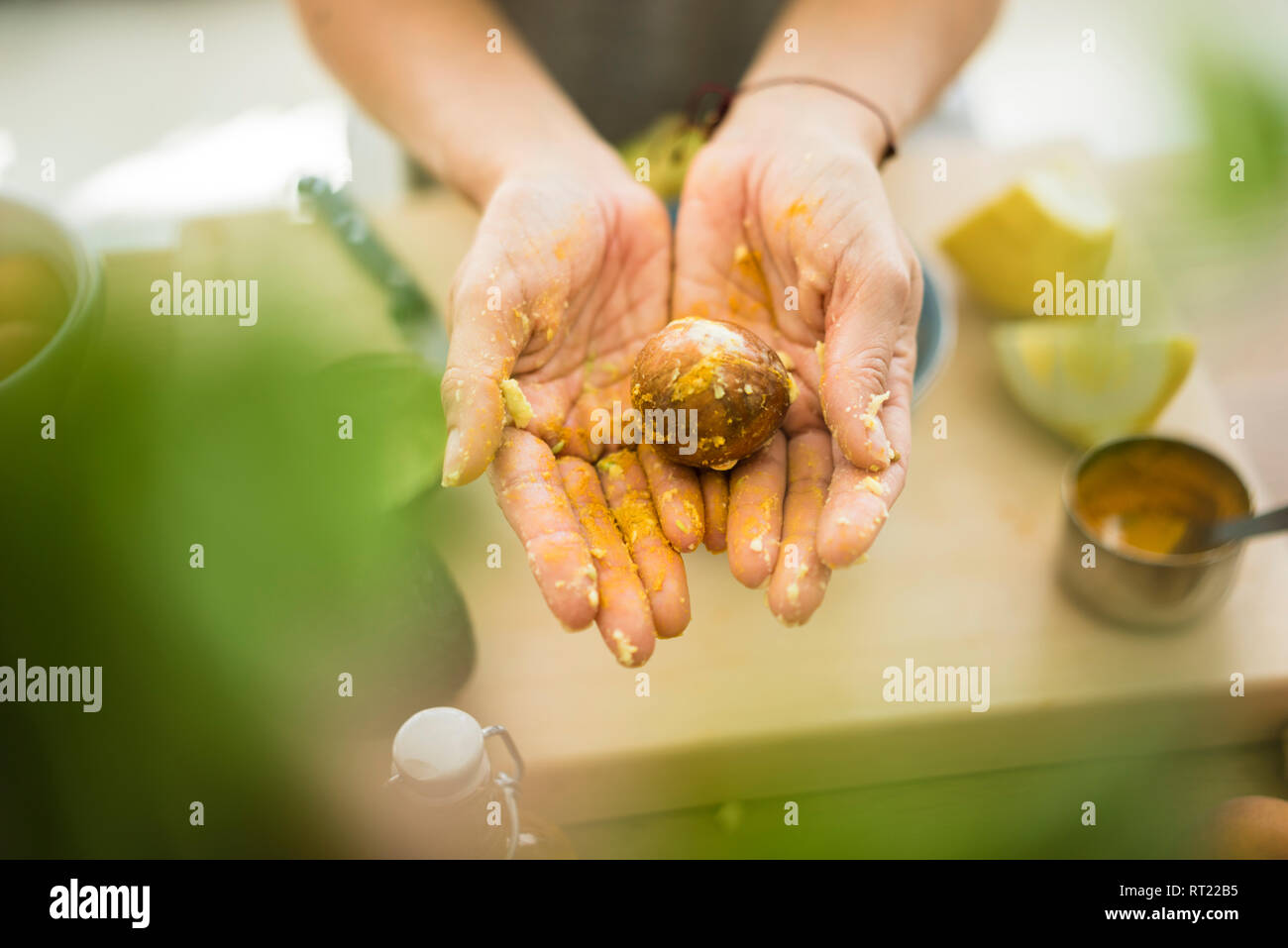 Messy hands holding avocado pit Stock Photo