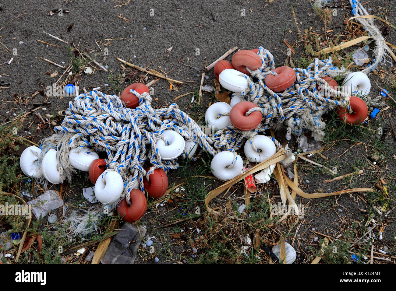 Mixed up ropes with lot of buoys on the beach with garbage. Stock Photo