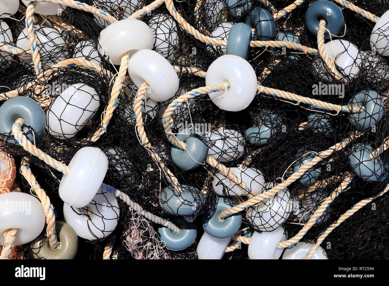 Mixed up fishnet with rope and lot of buoys texture, Nautical marina background. Stock Photo