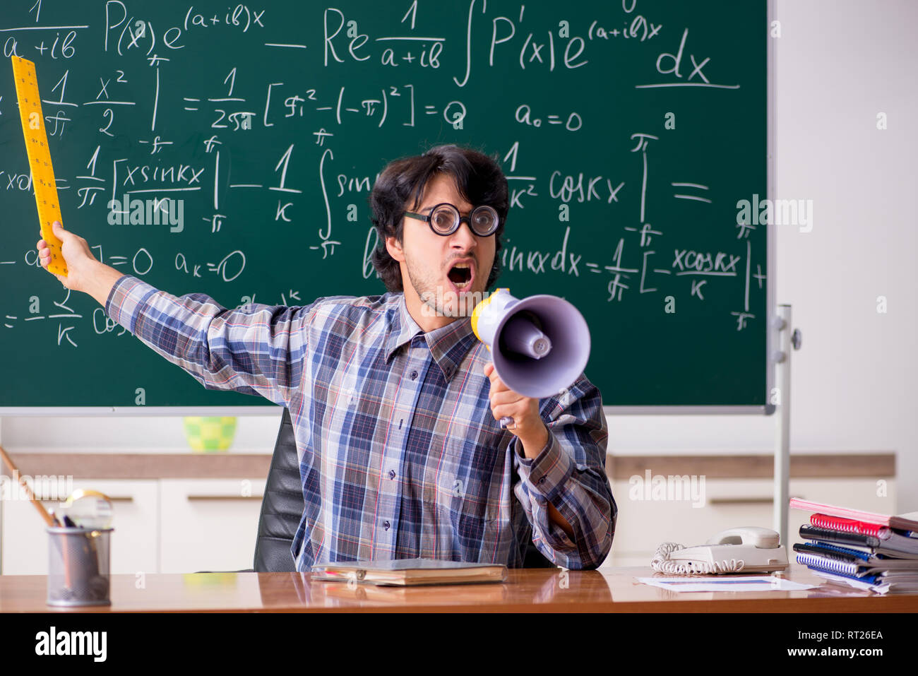 Funny male math teacher in the classroom Stock Photo - Alamy