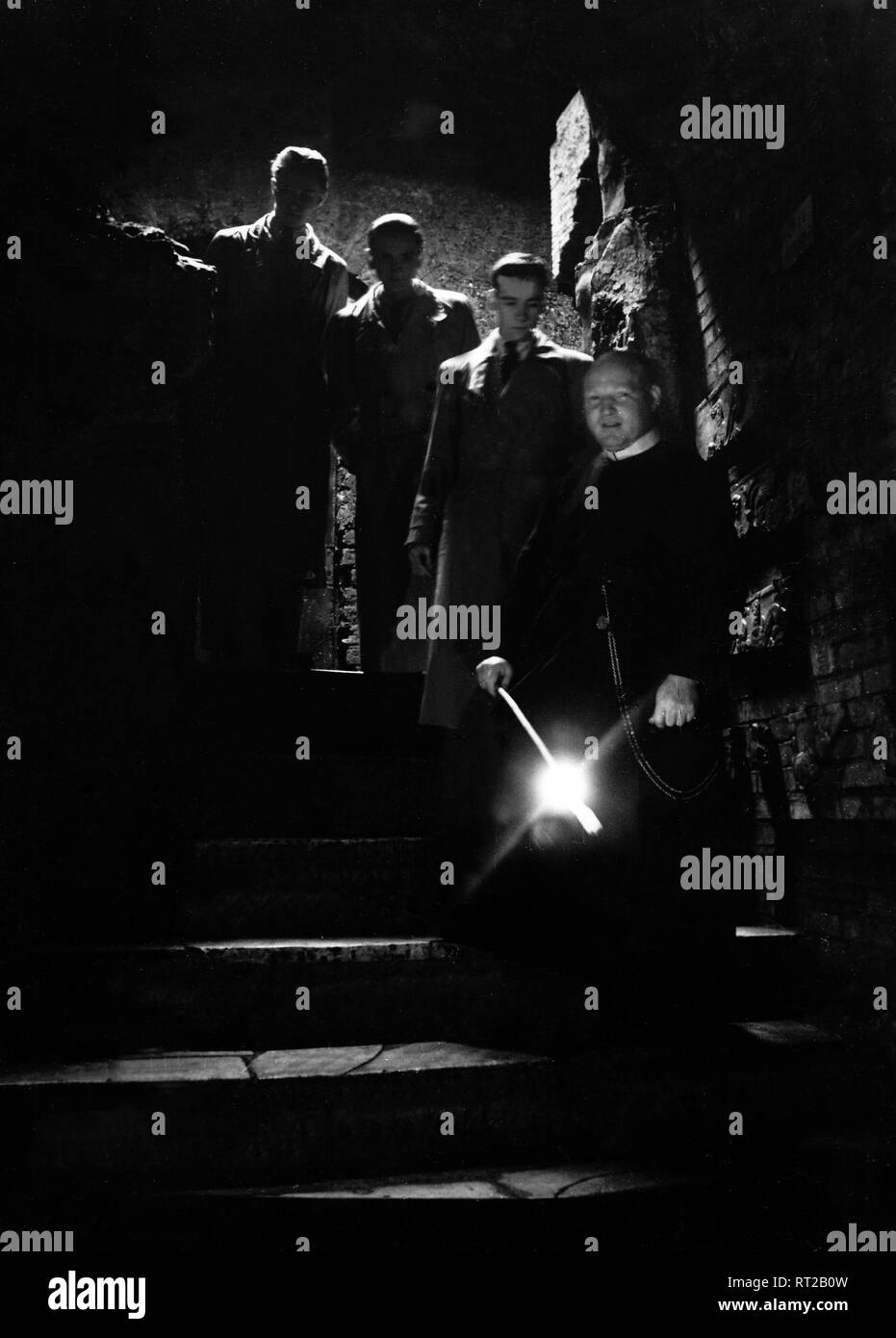 Travel to Rome - Italy in 1950s - Priest and visitors on the staircase to the Catacombs in Rome. Image taken in 1954 by Erich Andres Stock Photo
