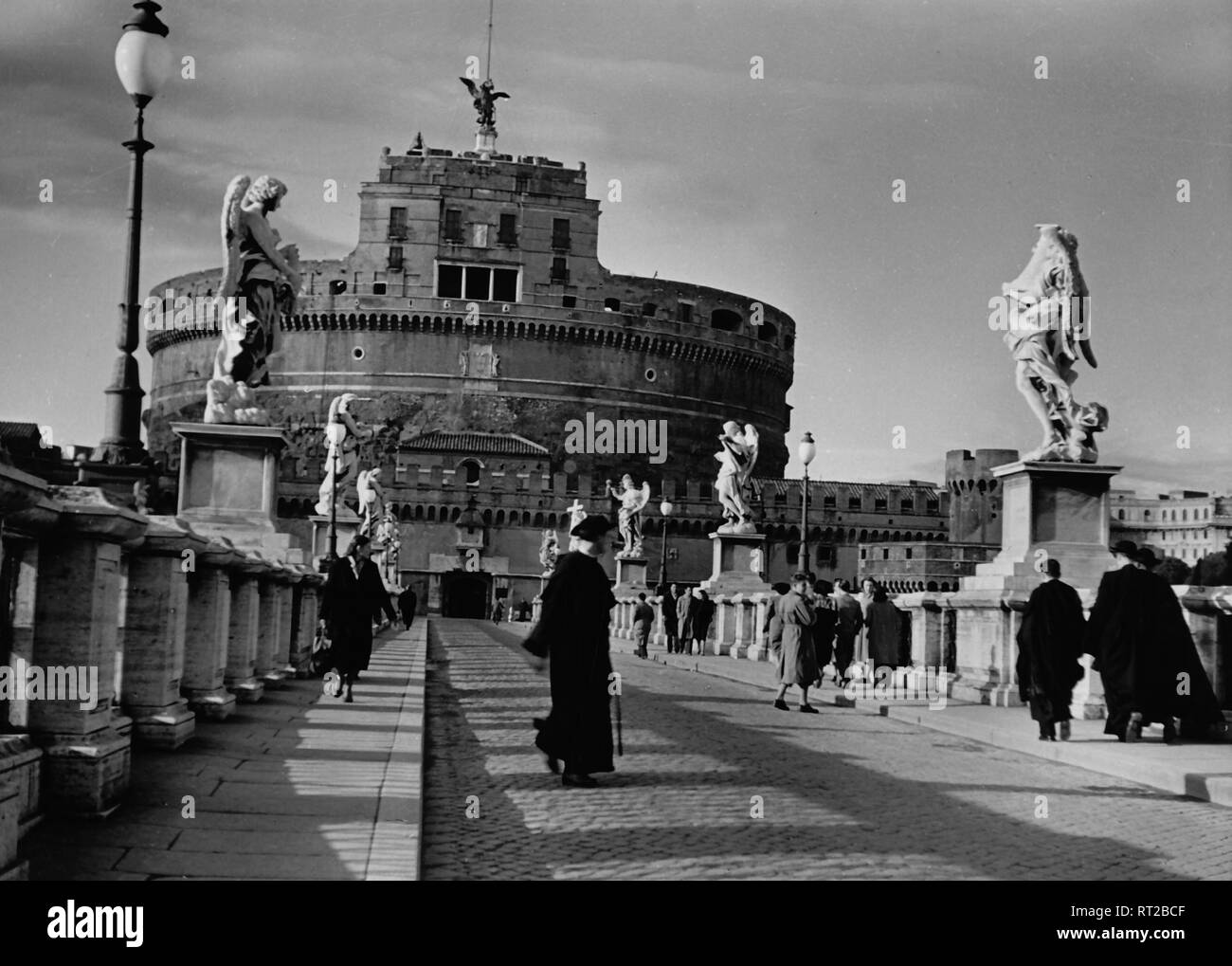 Travel to Rome - Italy in 1950s - priests crossing the St. Angel Bridge. In the background the Castel Sant' Angelo  in Rome. Engelsburg und Engelsbrücke in Rom, Italien. Image date 1954. Photo Erich Andres Stock Photo