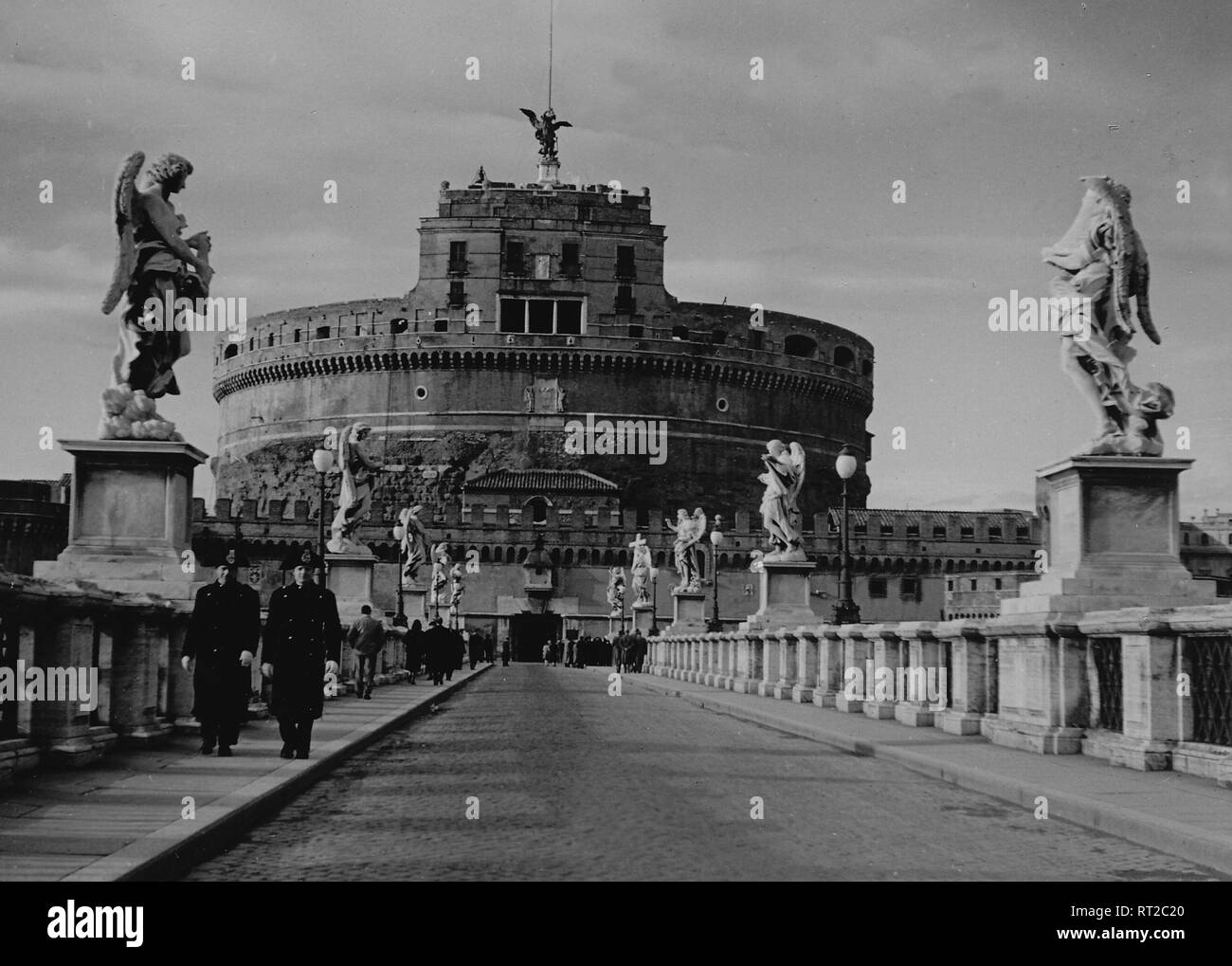 Travel to Rome - Italy in 1950s - Gendarmerie Corps of Vatican City State crossing the St Angel Bridge. In the background the Castel Saint' Angelo in Rome. Engelsburg und Engelsbrücke in Rom, Italien. Image date 1954. Photo by Erich Andres Stock Photo