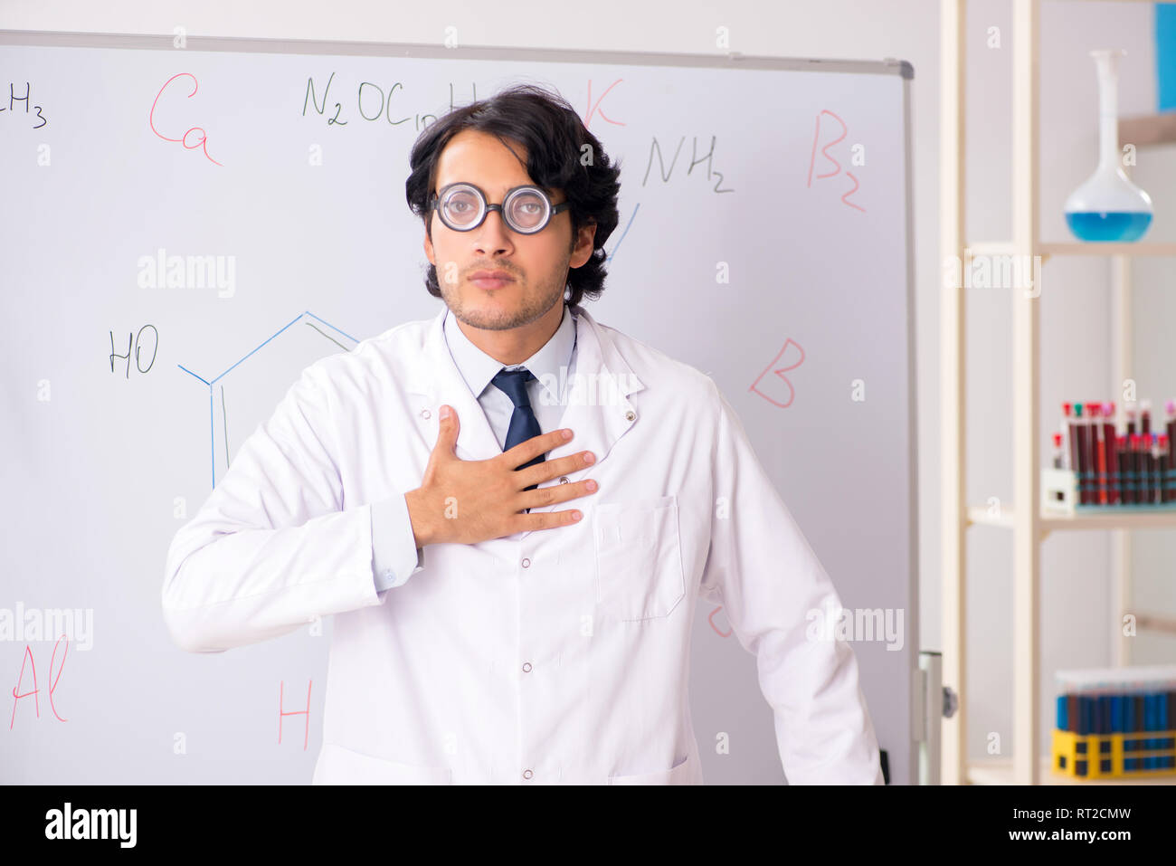 Young funny chemist in front of white board Stock Photo