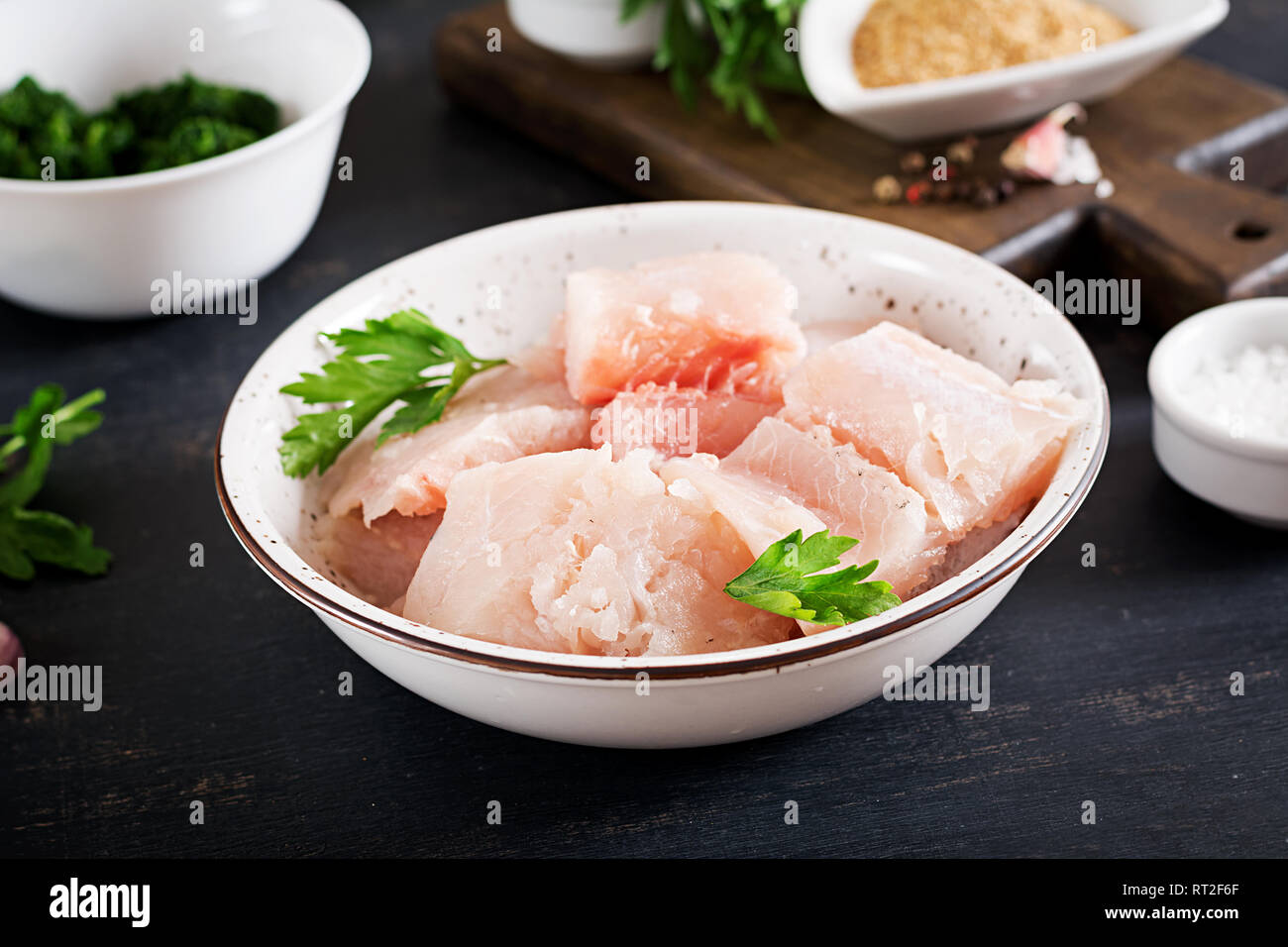 Ingredients for homemade Fish Cake cod, spinach, egg and breadcrumbs. Raw cutlets from minced cod. Stock Photo