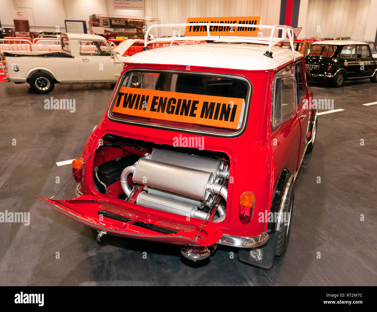 Rear view of a 1965, Twin-engine, Austin Mini Cooper S, on display at the 2019 London Classic Car Show. Showing the exhaust system in the boot. Stock Photo