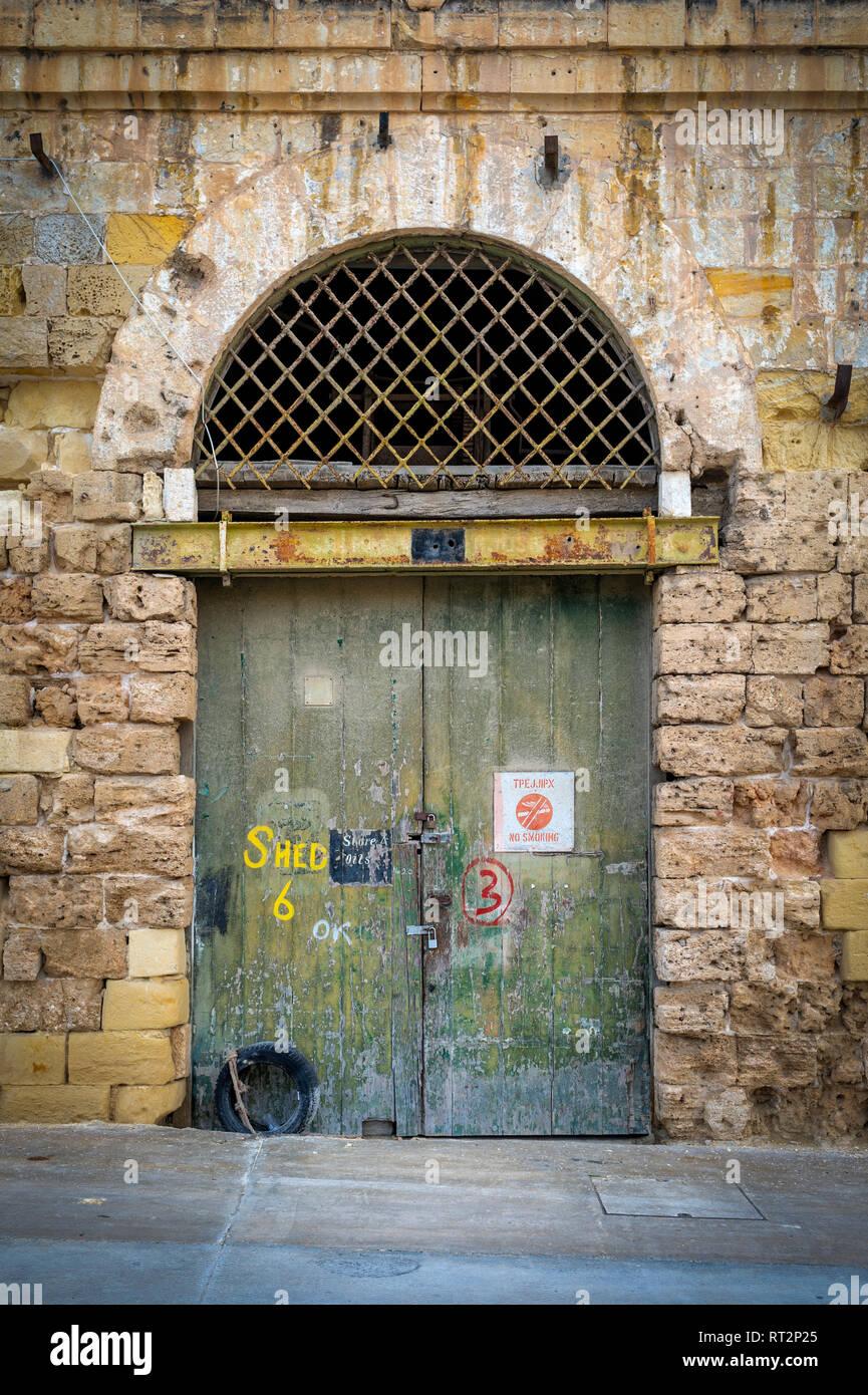 old arched warehouse doorway with green painted doors Stock Photo