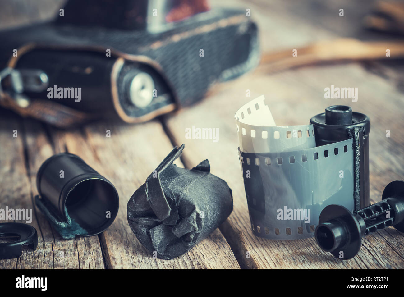 Old photo film rolls and cassette, vintage camera on background. Retro toned. Stock Photo