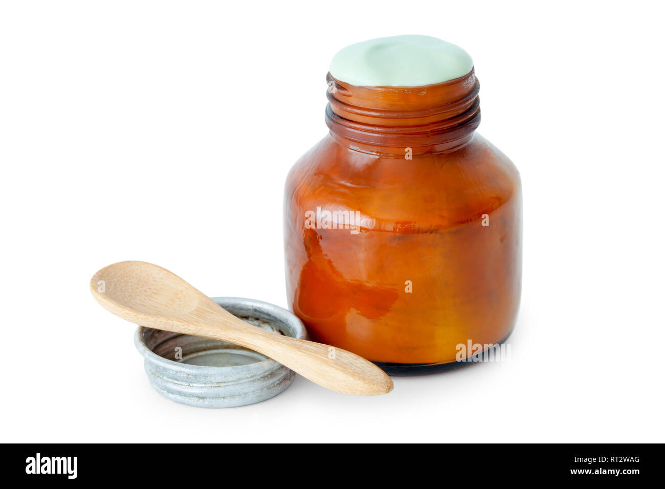 A balm jar full of medicated ointment in green color and spoon on white background. Stock Photo