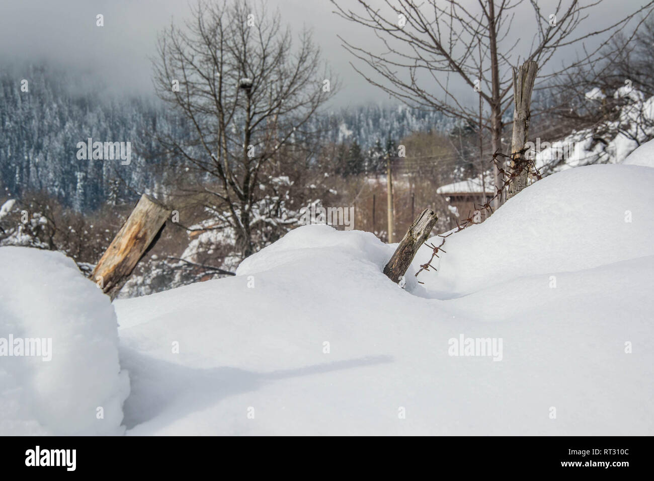 Fence details covered in snow in winter landscape - iced barb wire and ...