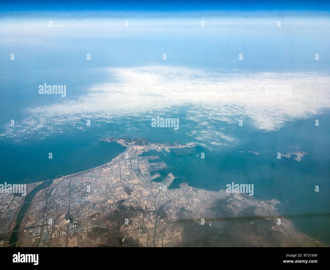 An aerial view of the Zhifu island near Jen-tchaj in China from the airplane flying high above the ground. A look from the plane´s window. Stock Photo