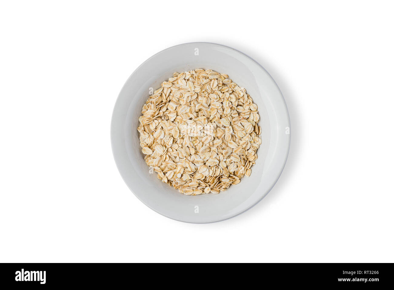white plate with oat flakes on white background Stock Photo