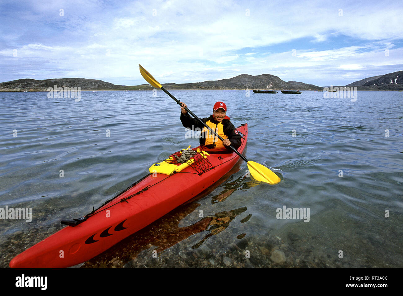 Inuit in a canoo on the water near Cape Dorset at the Hudson Bay in Canada Stock Photo