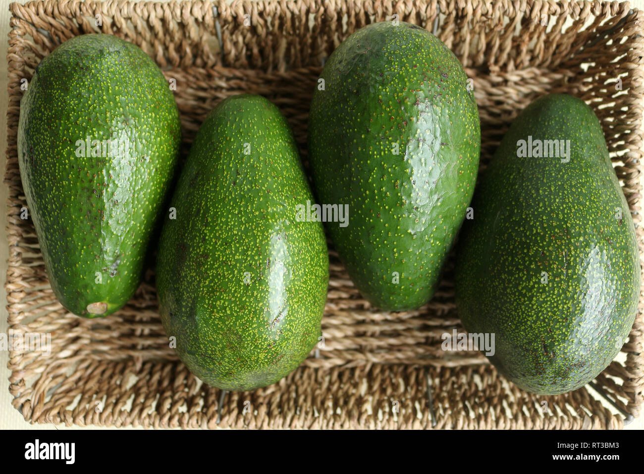 https://c8.alamy.com/comp/RT3BM3/overhead-shot-of-four-green-avocados-in-a-rectangular-shaped-straw-fruit-basket-RT3BM3.jpg