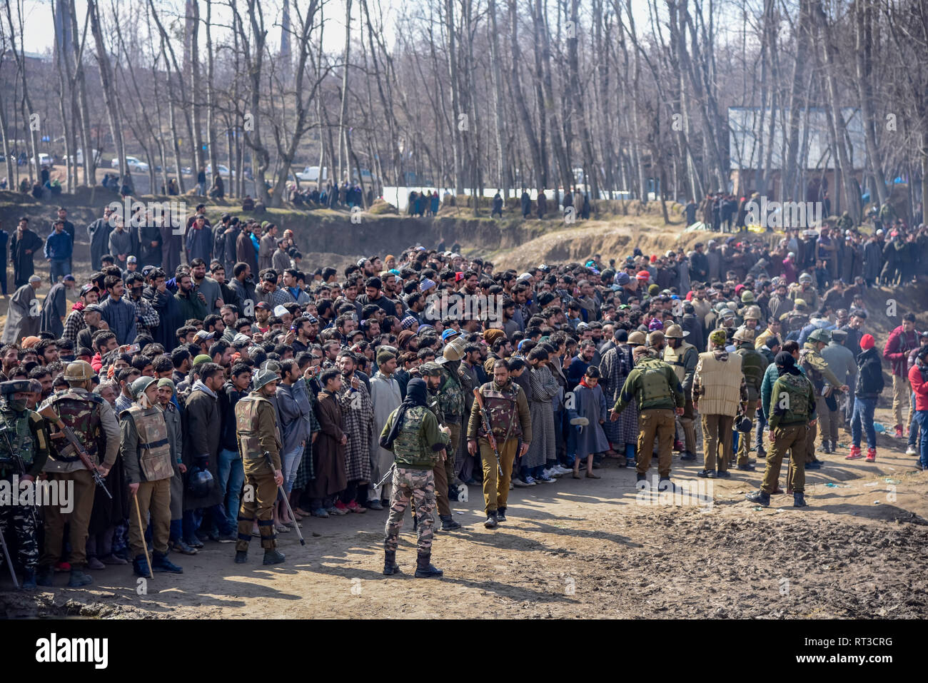 Indian army men are seen standing on guard as the kashmiri villagers gathered near the wreckage of an aircraft that crashed in Budgam area. A civilian and six Indian Air Force personnel were killed after a Mi-17 chopper crashed near Garend Kalan village in Budgam which is some 30 Kms from Summer Capital Srinagar Kashmir. Stock Photo