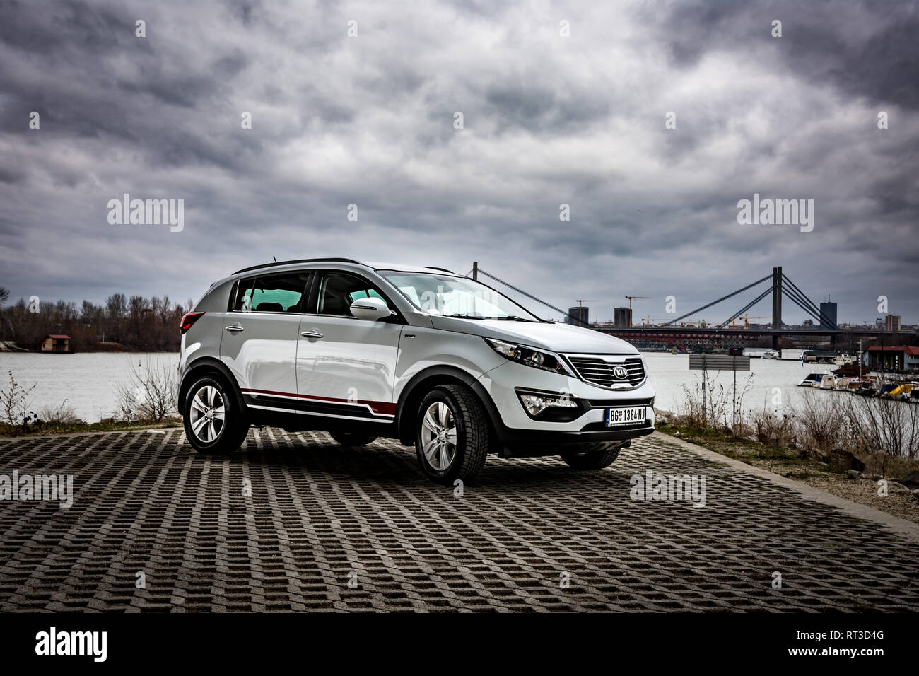 SUV Kia Sportage 2.0 CRDI awd or 4x4, white color, parked on the banks of the river Sava, on the stormy weather with gloomy clouds. Stock Photo