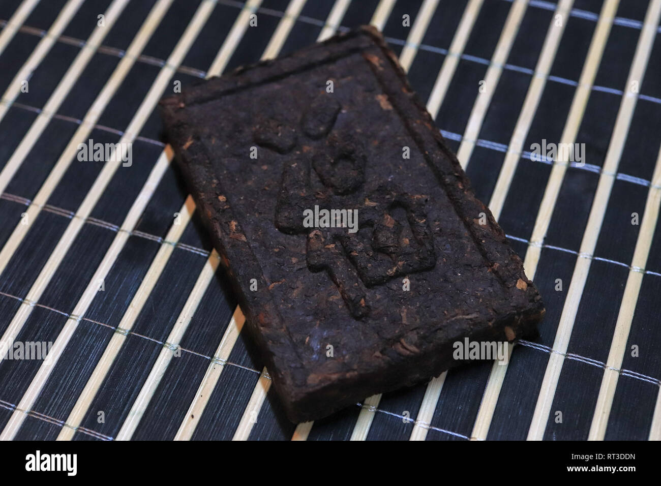 Pressed tea brick with Chinese hieroglyphs. Press tea texture Stock