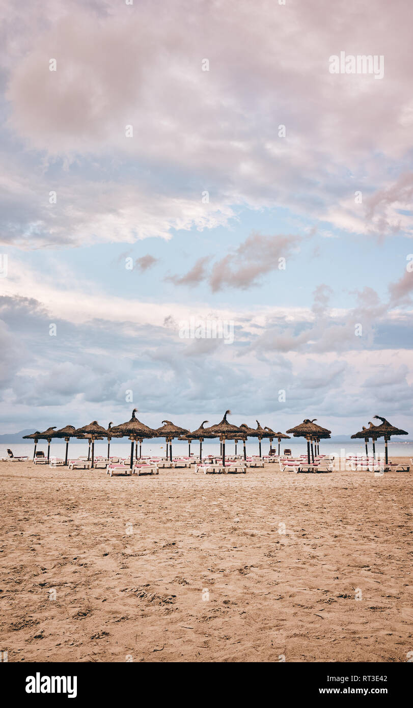 Beach with umbrellas and sunbeds, color toned picture. Stock Photo