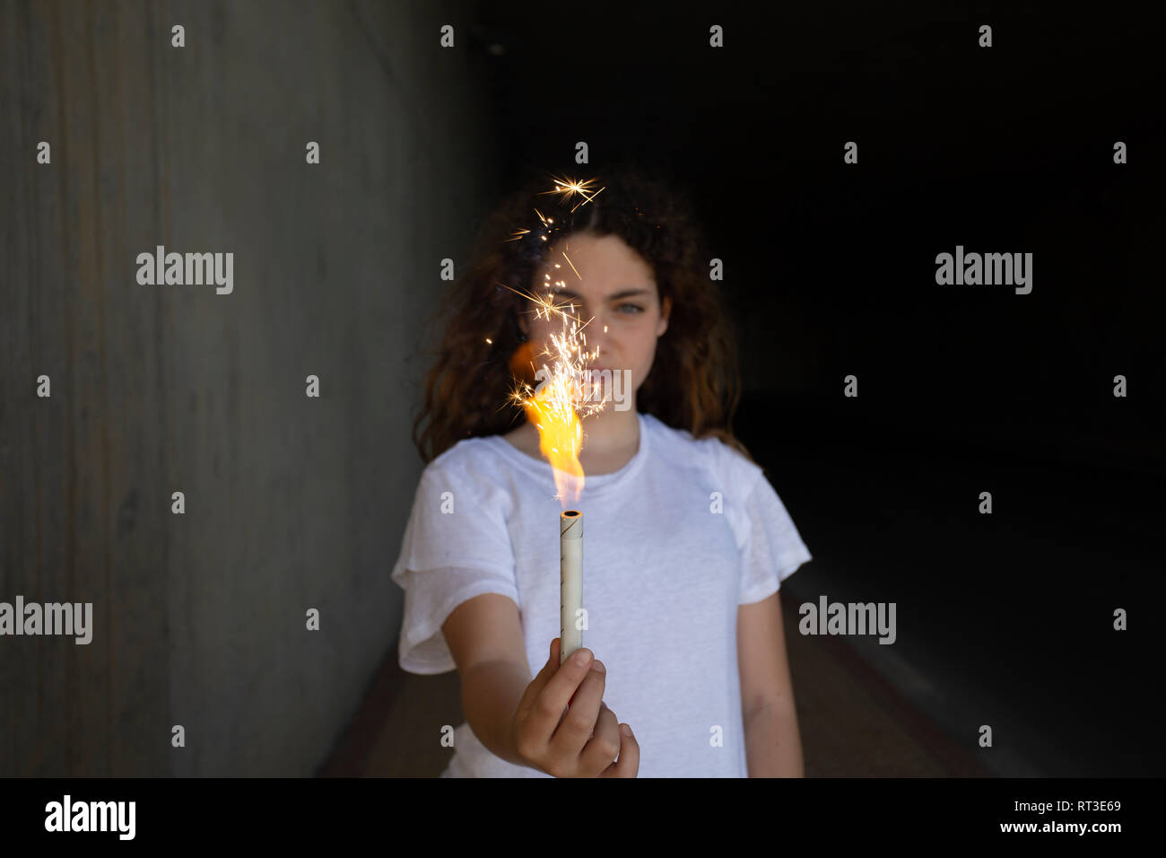 Girl holding sparkler in the dark Stock Photo