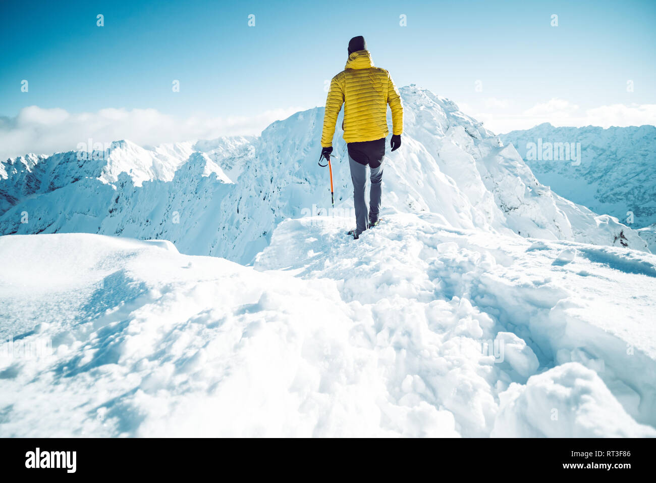 A climber ascending a mountain in winter Stock Photo