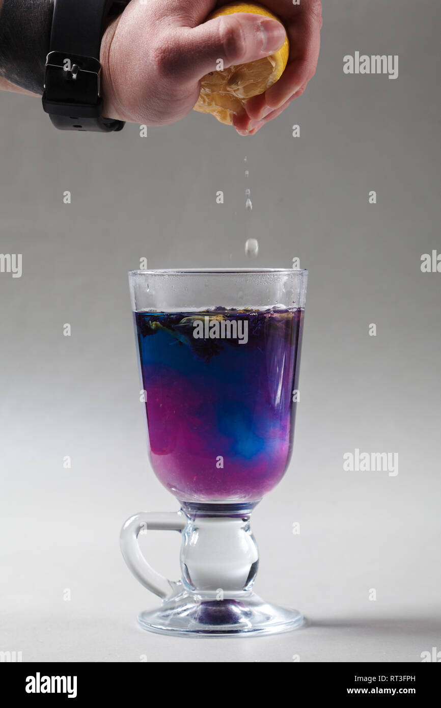 Thai blue butterfly pea tea in an Irish glass on a gray background