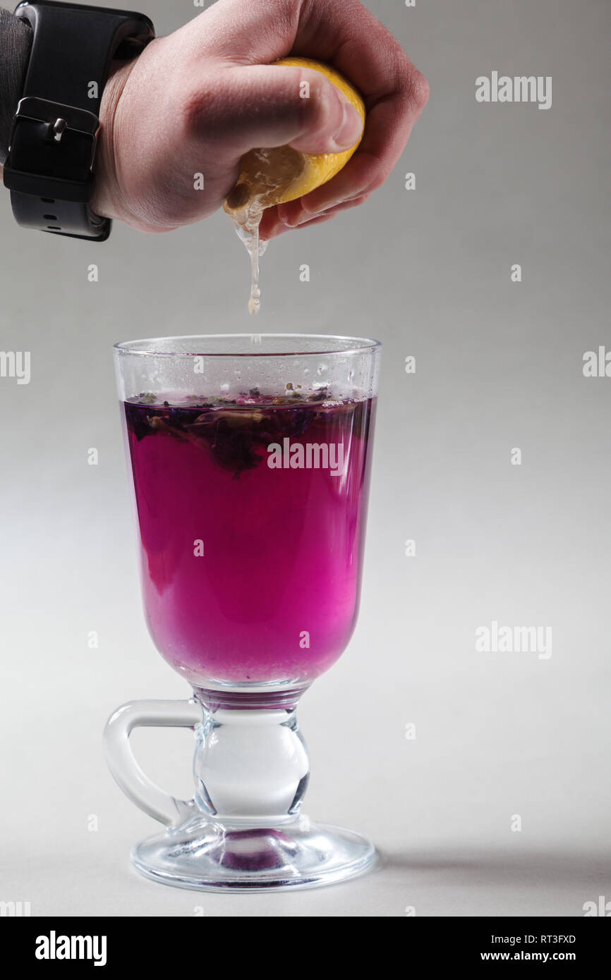 Thai blue butterfly pea tea in an Irish glass on a gray background