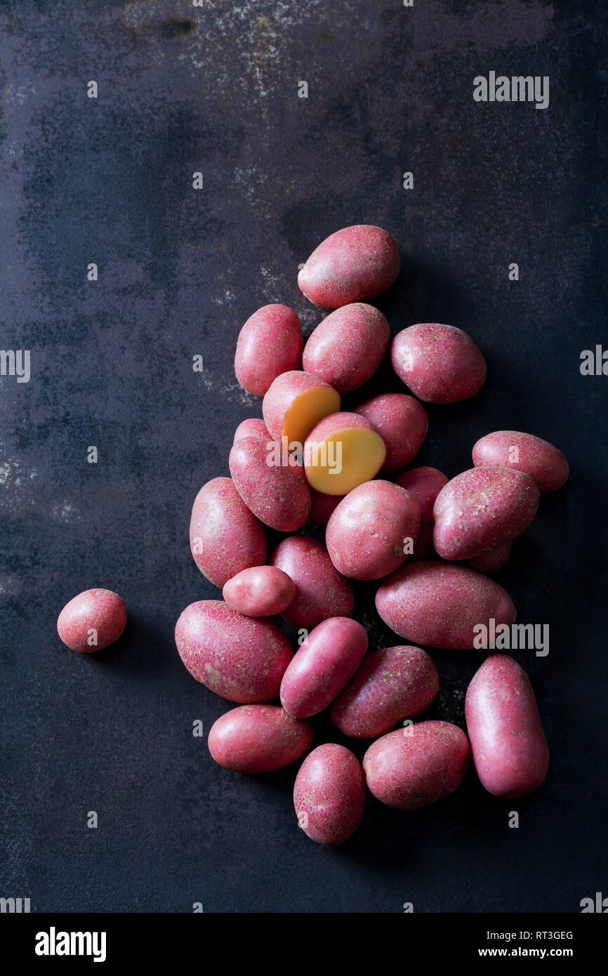 Sliced and whole red baby potatoes on rusty metal Stock Photo