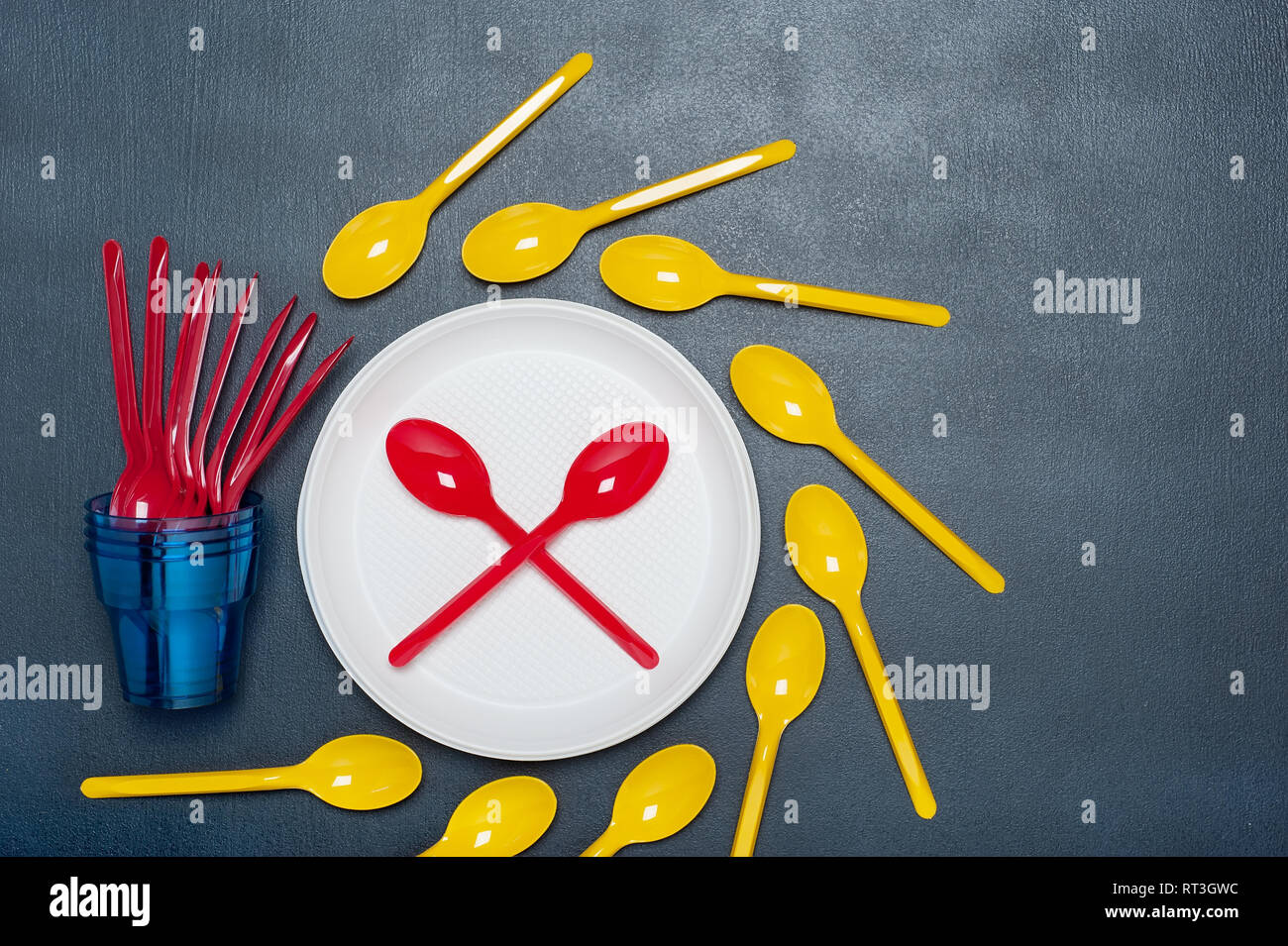 Set of  plastic tableware bowls, spoons,  and forks on gray  background. Flat lay, top view. Ecology concept. Stock Photo