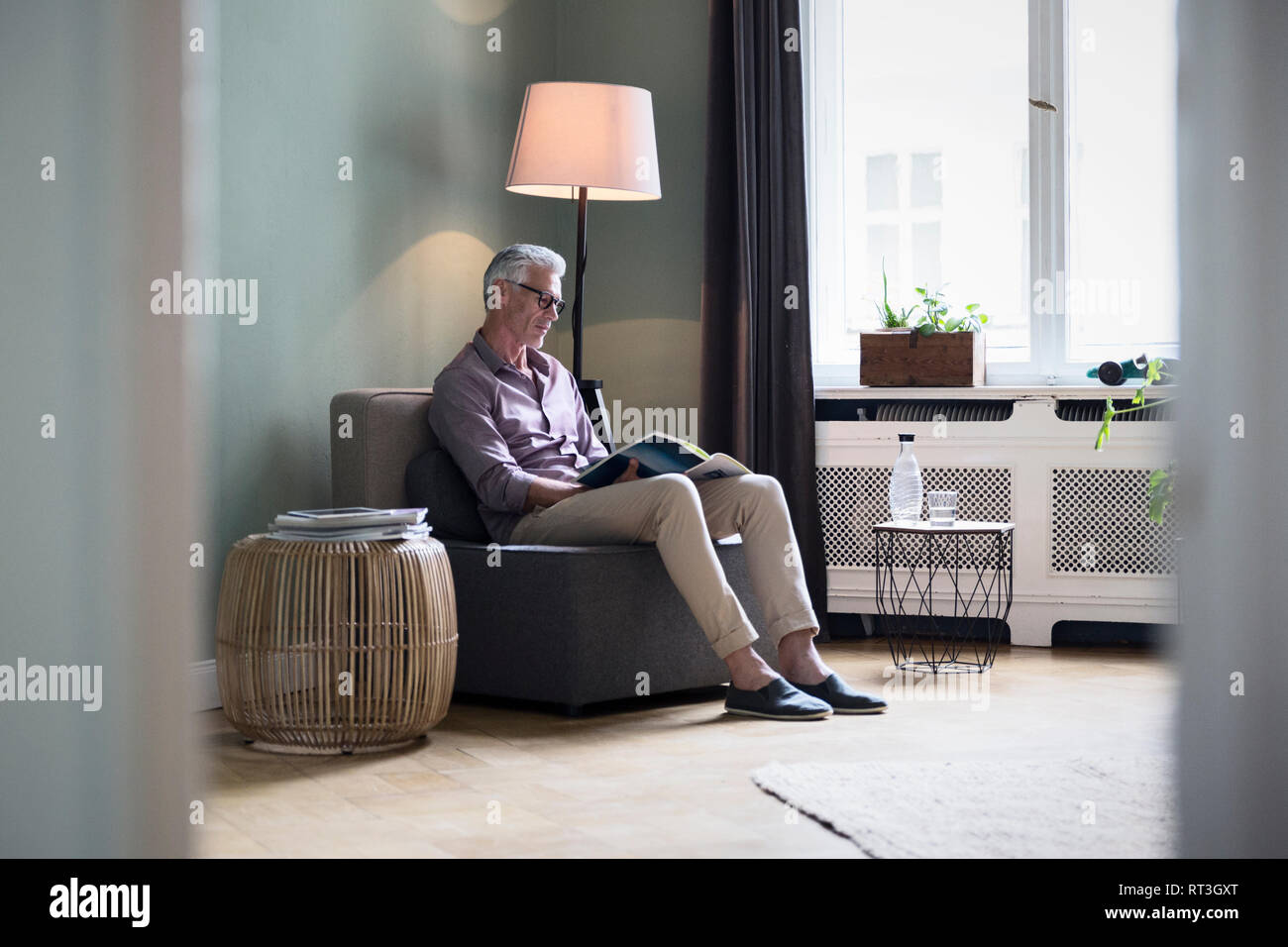 Mature man reading magazine at home Stock Photo