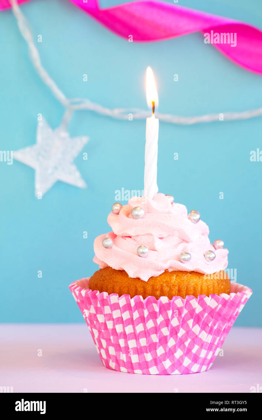 Birthday cupcake with a burning candle Stock Photo