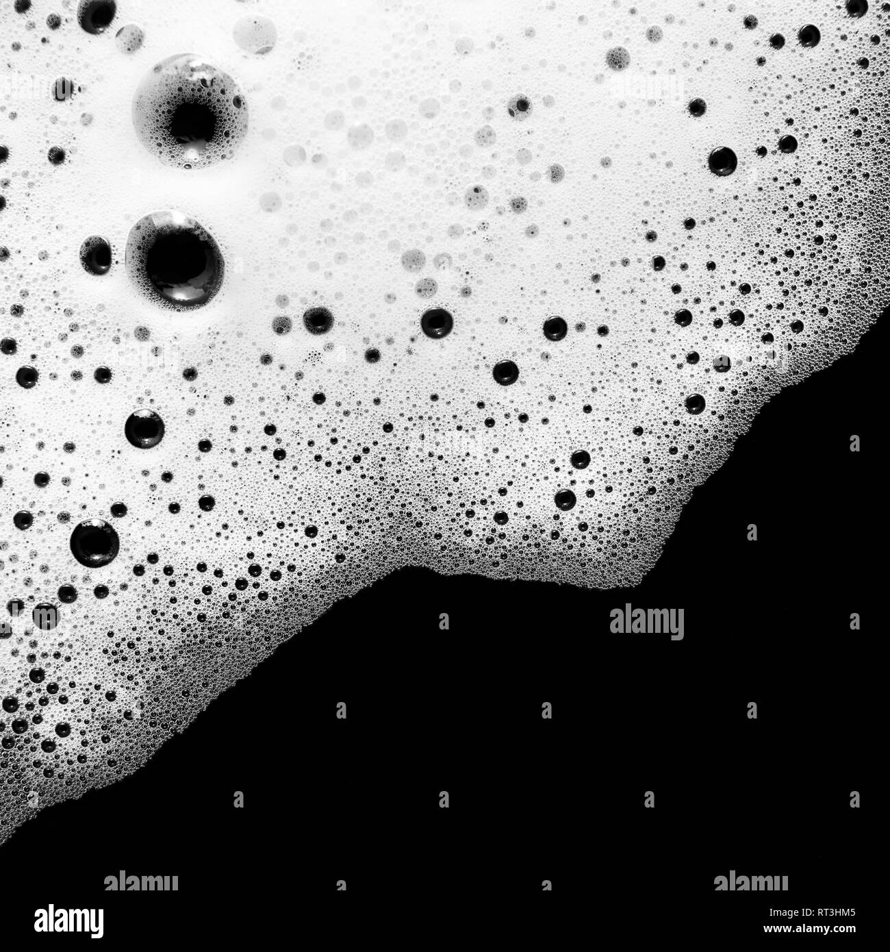 Foam with bubbles on black background. Soap sud. Detergent in water. Abstract soapy texture. Flat lay. Stock Photo