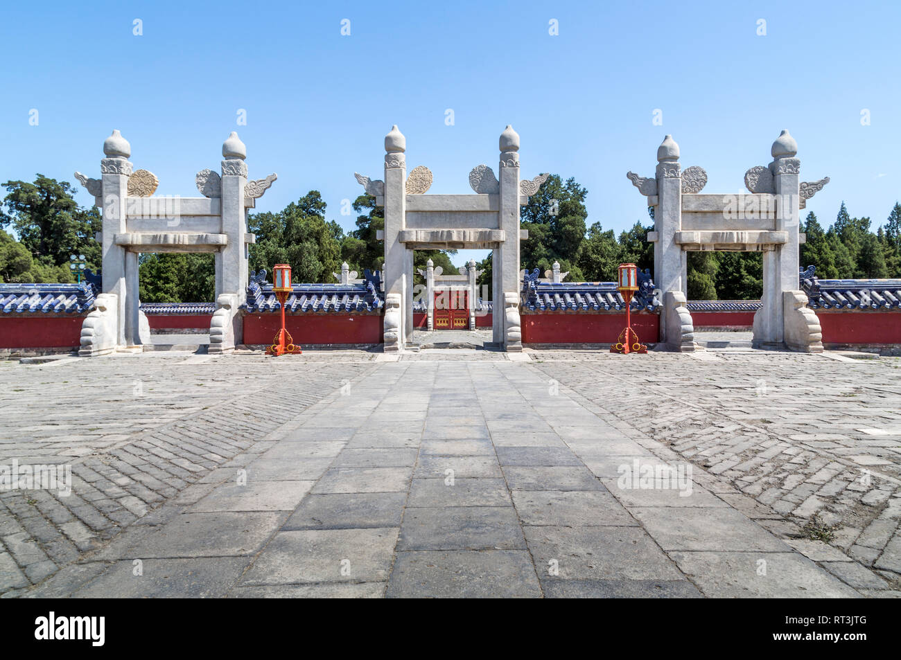 Linxing Gate of the Circular Mound Altar shown without any people in the shot. Three white marble gates stand out  amid the red walls and blue tiles. Stock Photo