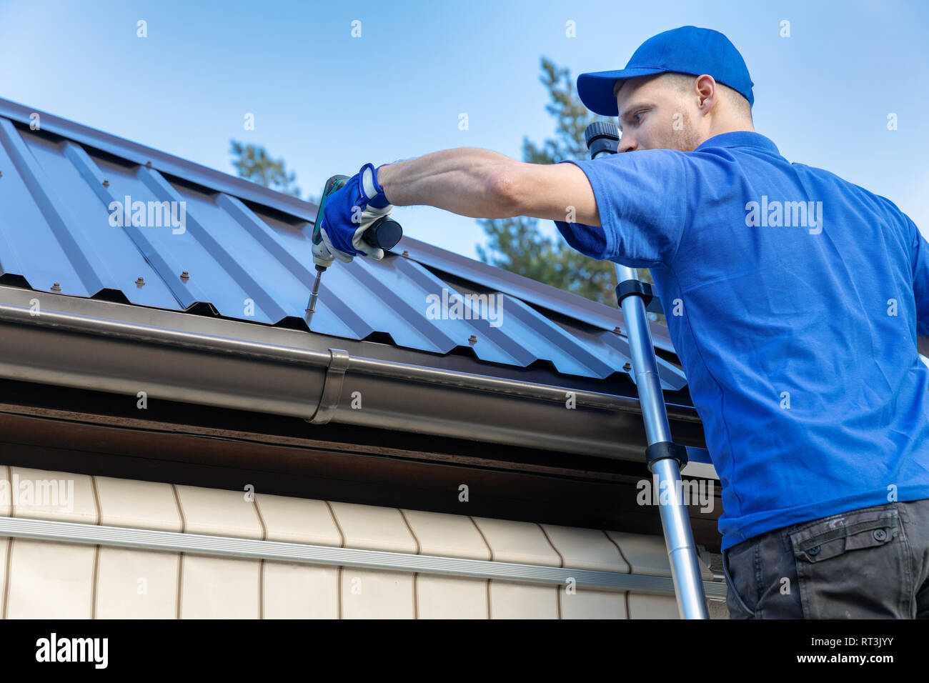 metal roofing - roofer working on the house roof Stock Photo