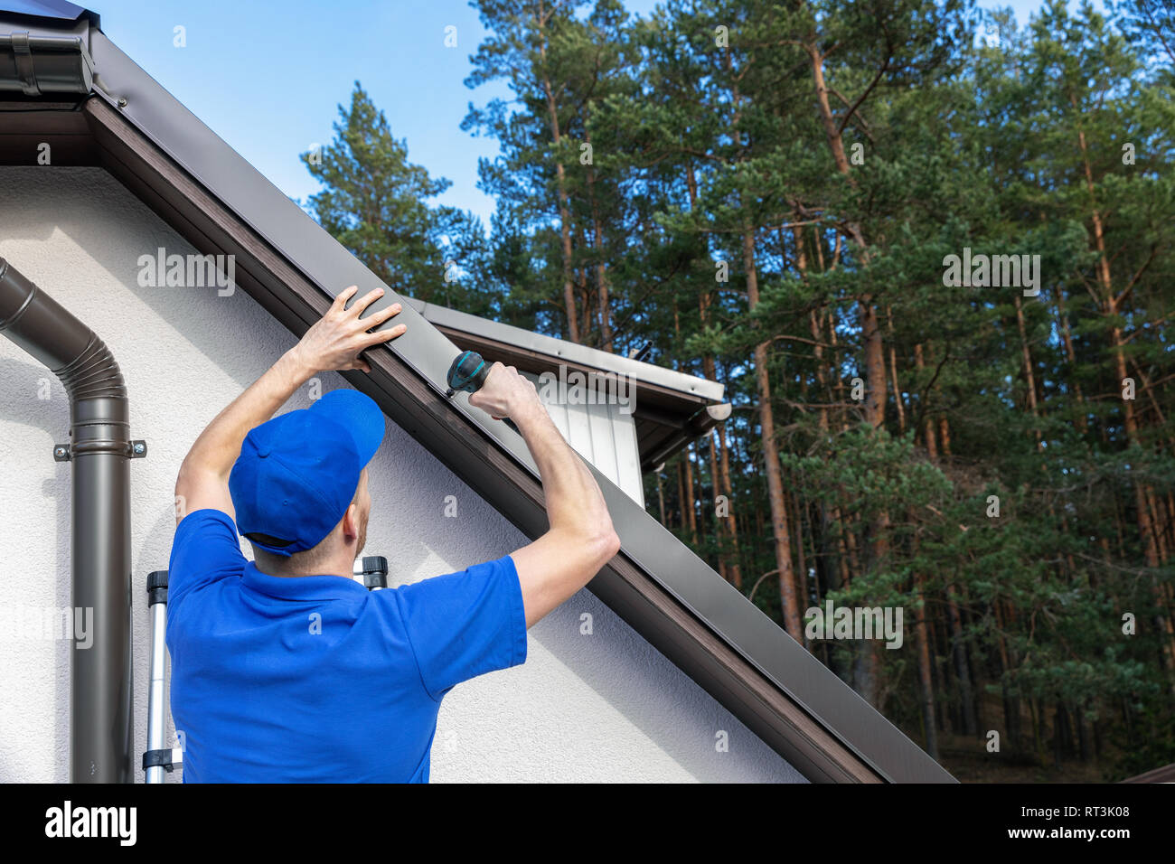 roofer installing metal drip edge profile on the house roof Stock Photo