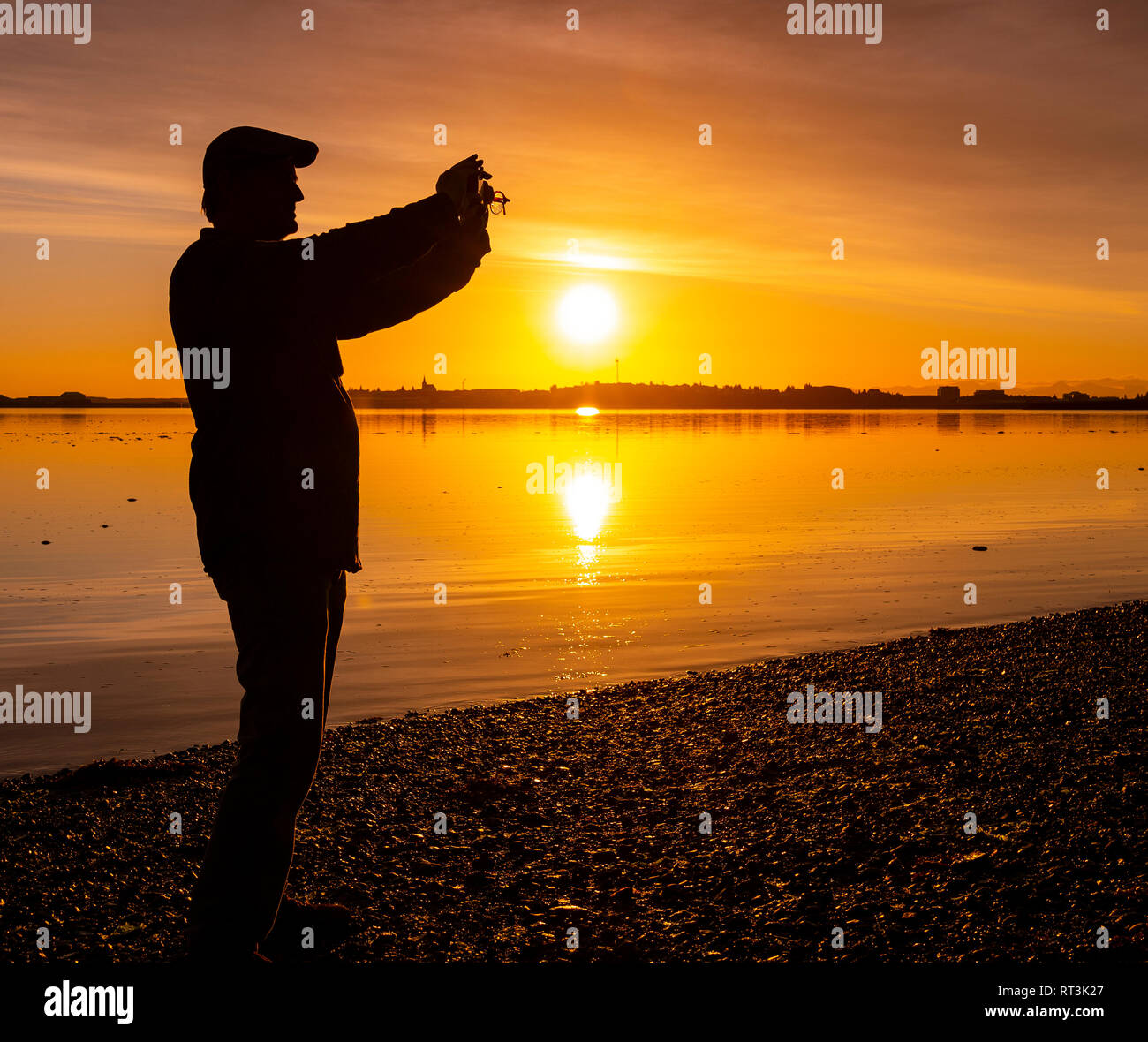 Man taking a picture at sunset, Borgarnes, Western Iceland Stock Photo