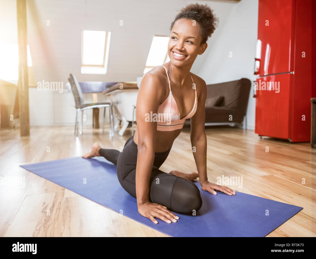 Smiling young woman practicing yoga Stock Photo
