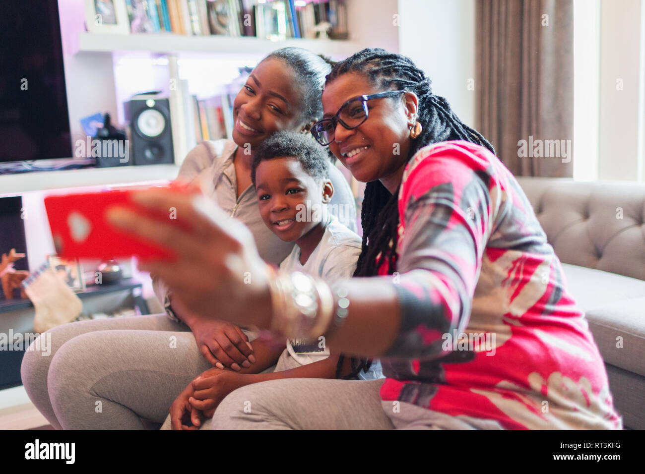 Multi-generation family taking selfie with camera phone in living room Stock Photo