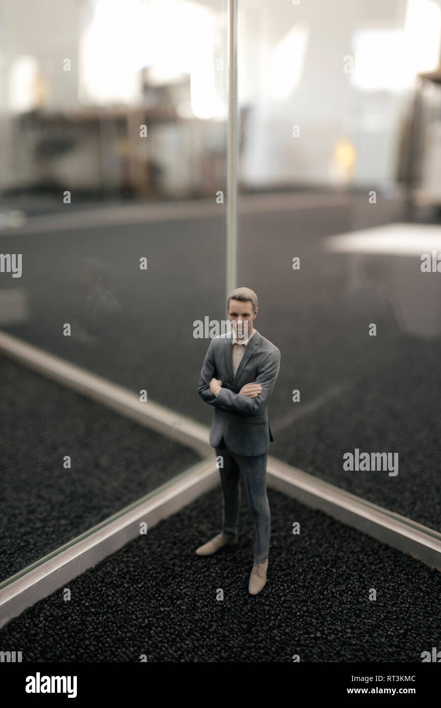 Businessman figurine standing between glass panes Stock Photo