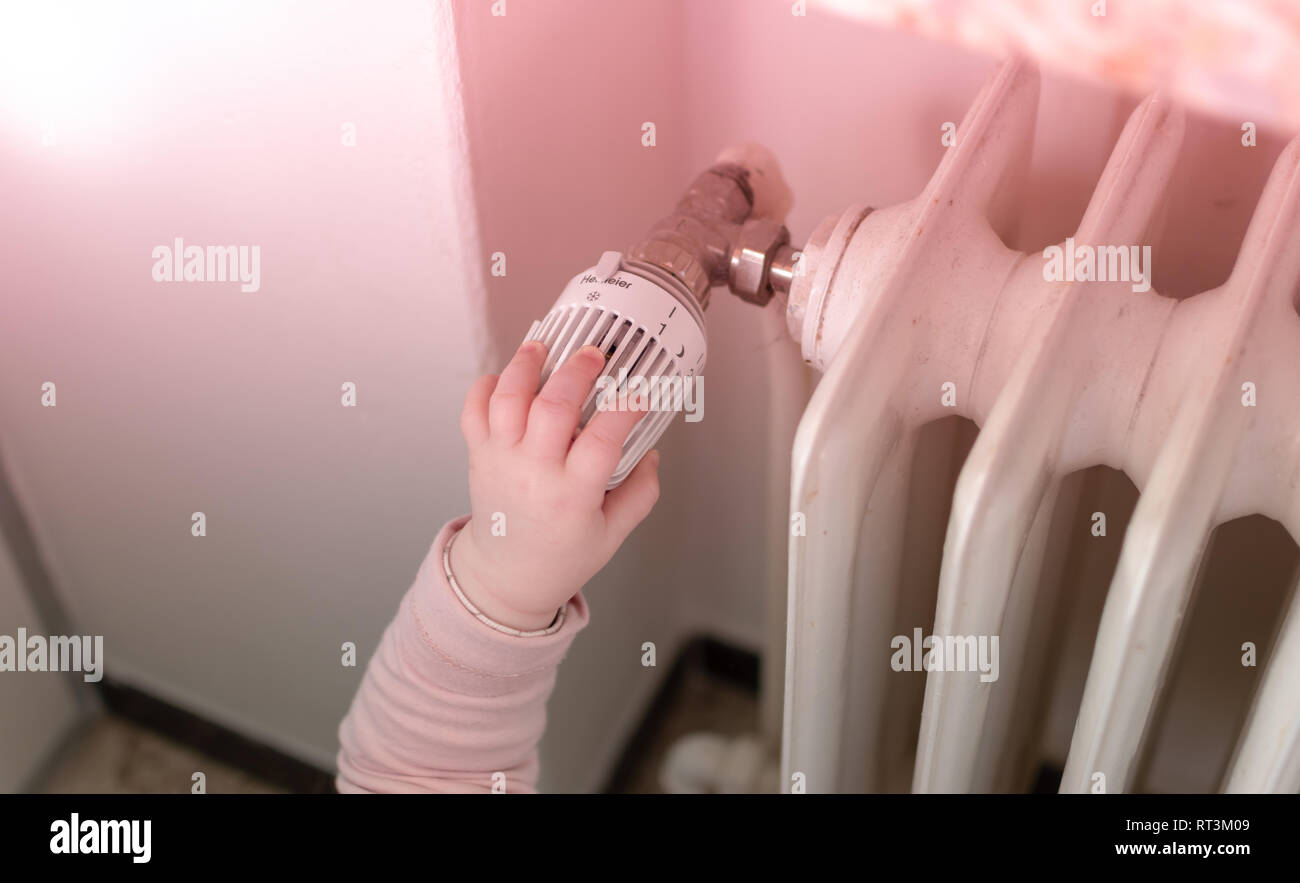 Baby is turning on the heating. Stock Photo
