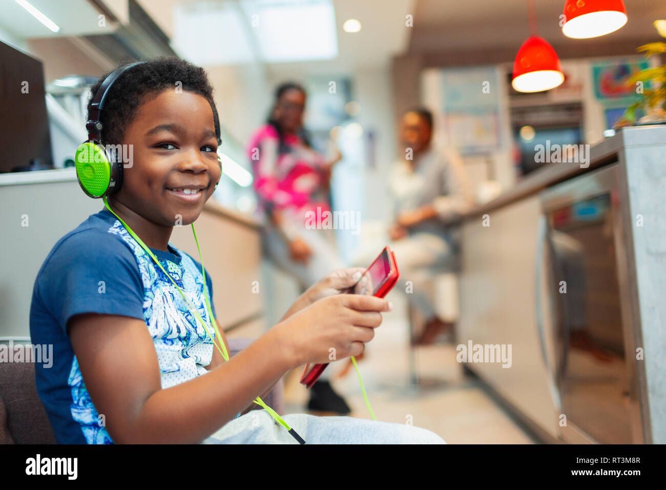 Portrait smiling, confident boy playing video game with headphones and digital tablet Stock Photo
