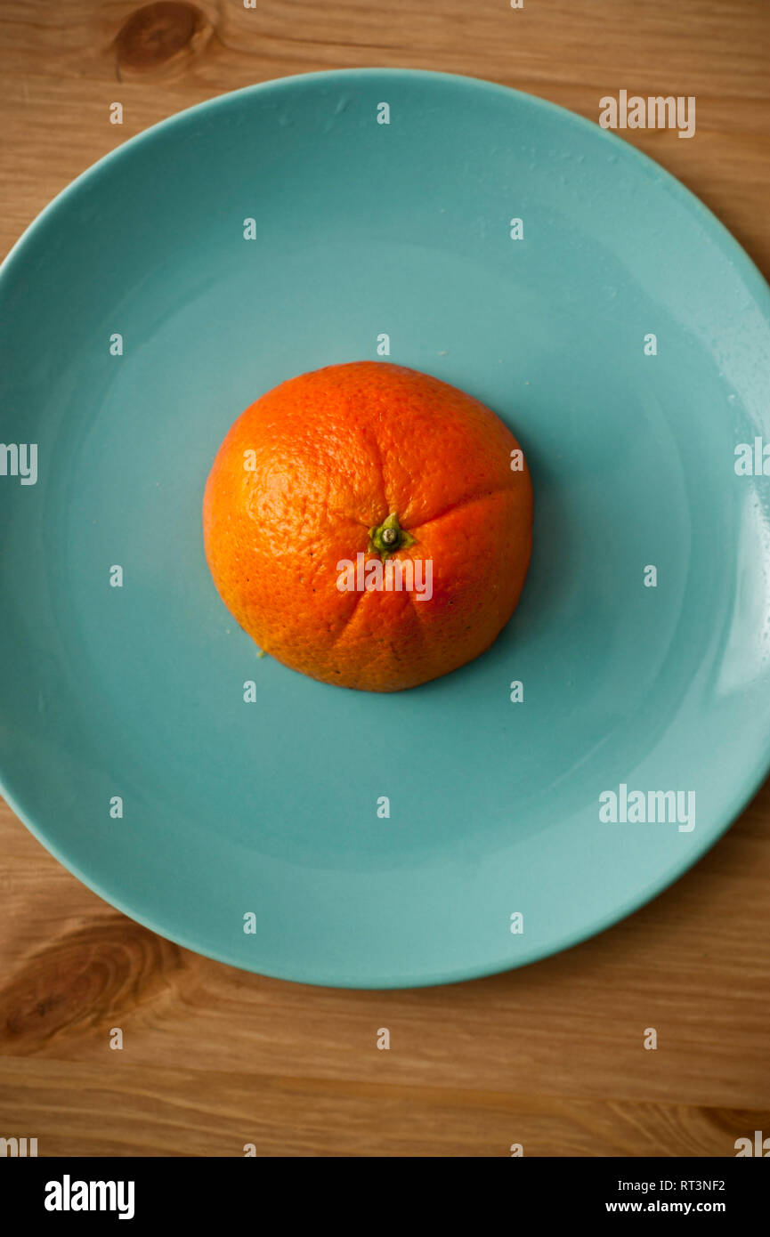 half orange fruit on a aquamarine blue plate Stock Photo