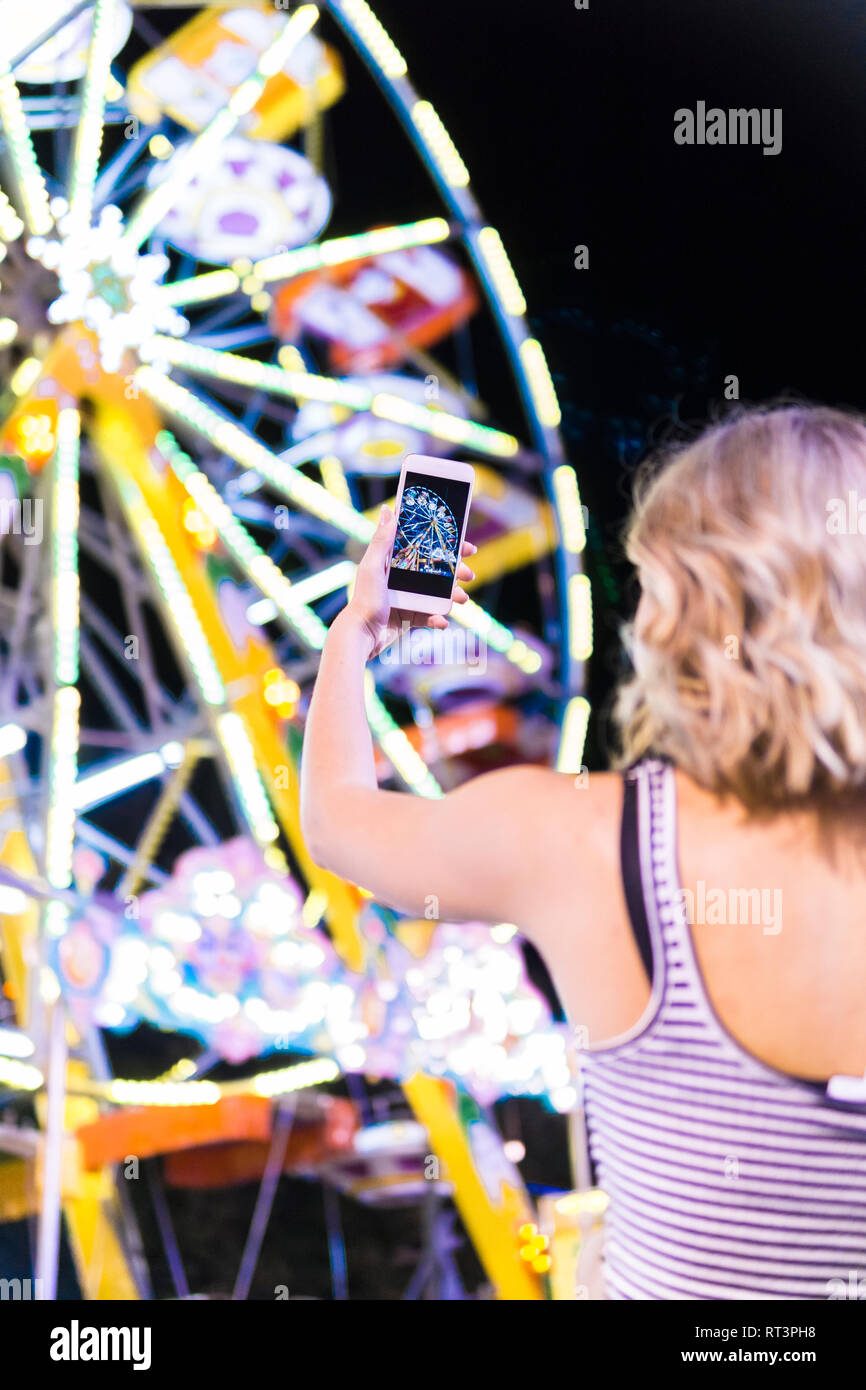 Back teenage girl taking photo big wheel fair hires stock photography
