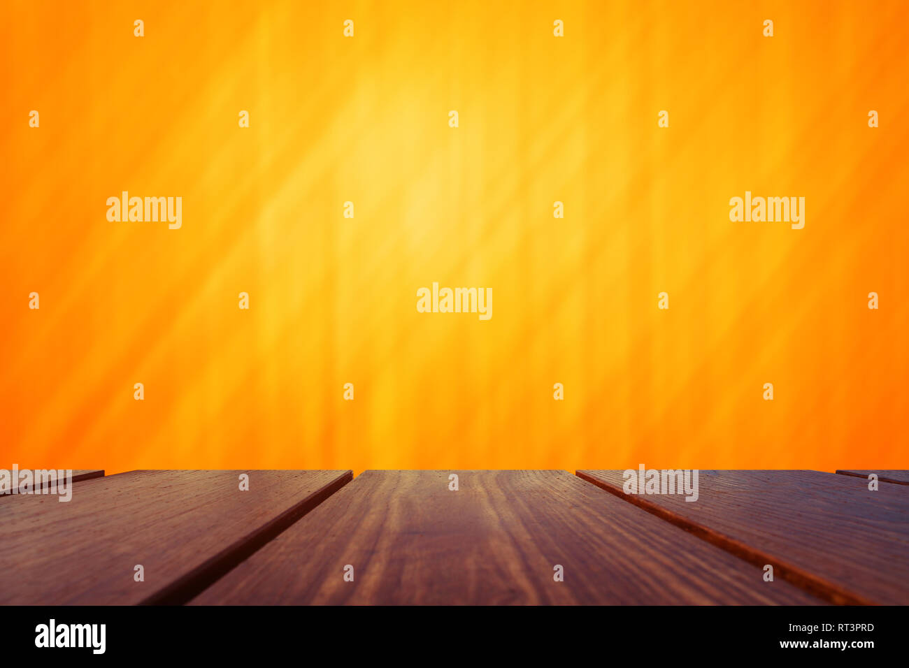 Wood Table Top and abstract orange background. Stock Photo