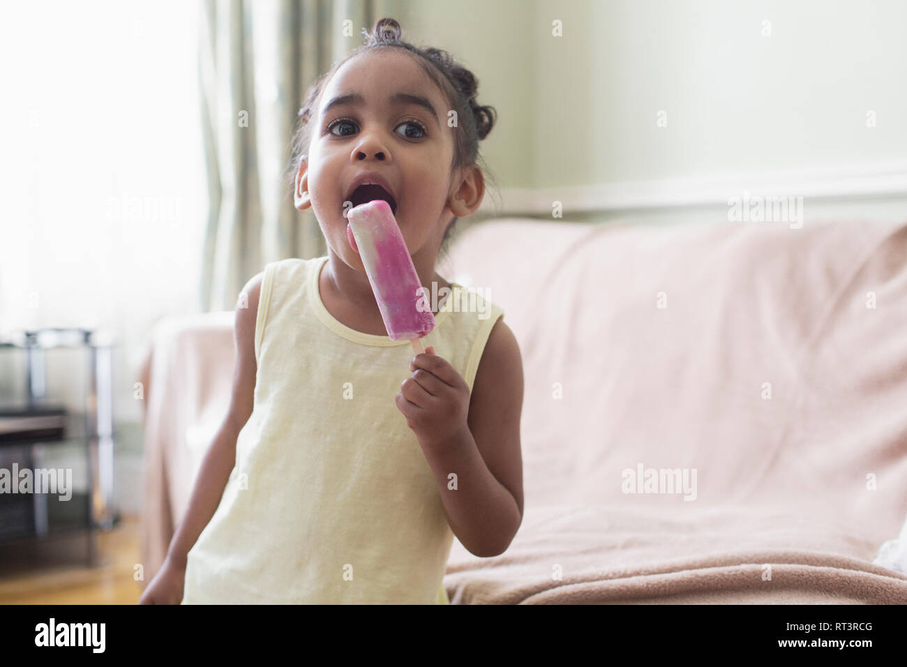 Cute toddler girl eating flavored ice Stock Photo