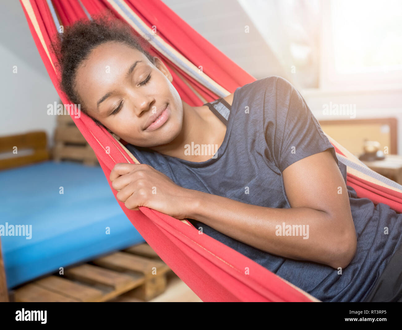 Smiling young woman sleeping in hammock Stock Photo